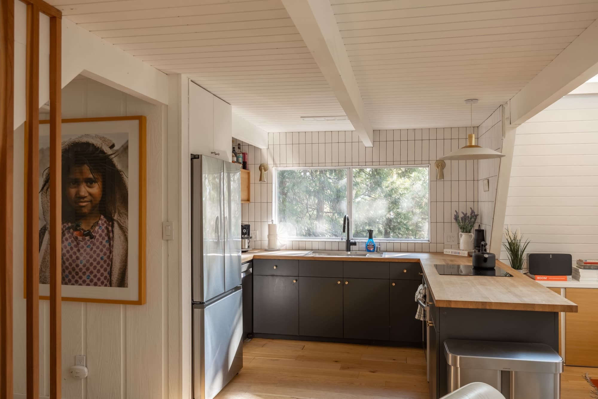 Modern kitchen with dark cabinets, butcher block counters, white tile backsplash, and Samsung appliances